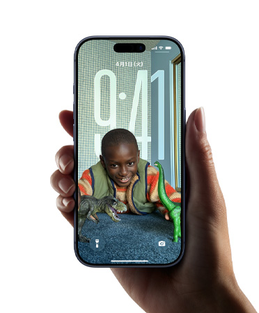 手に持ったiPhoneデバイス。ロック画面上の画像に合わせて時刻の表示を動的に変化させる新しいLiquid Glassのデザインが映し出されている