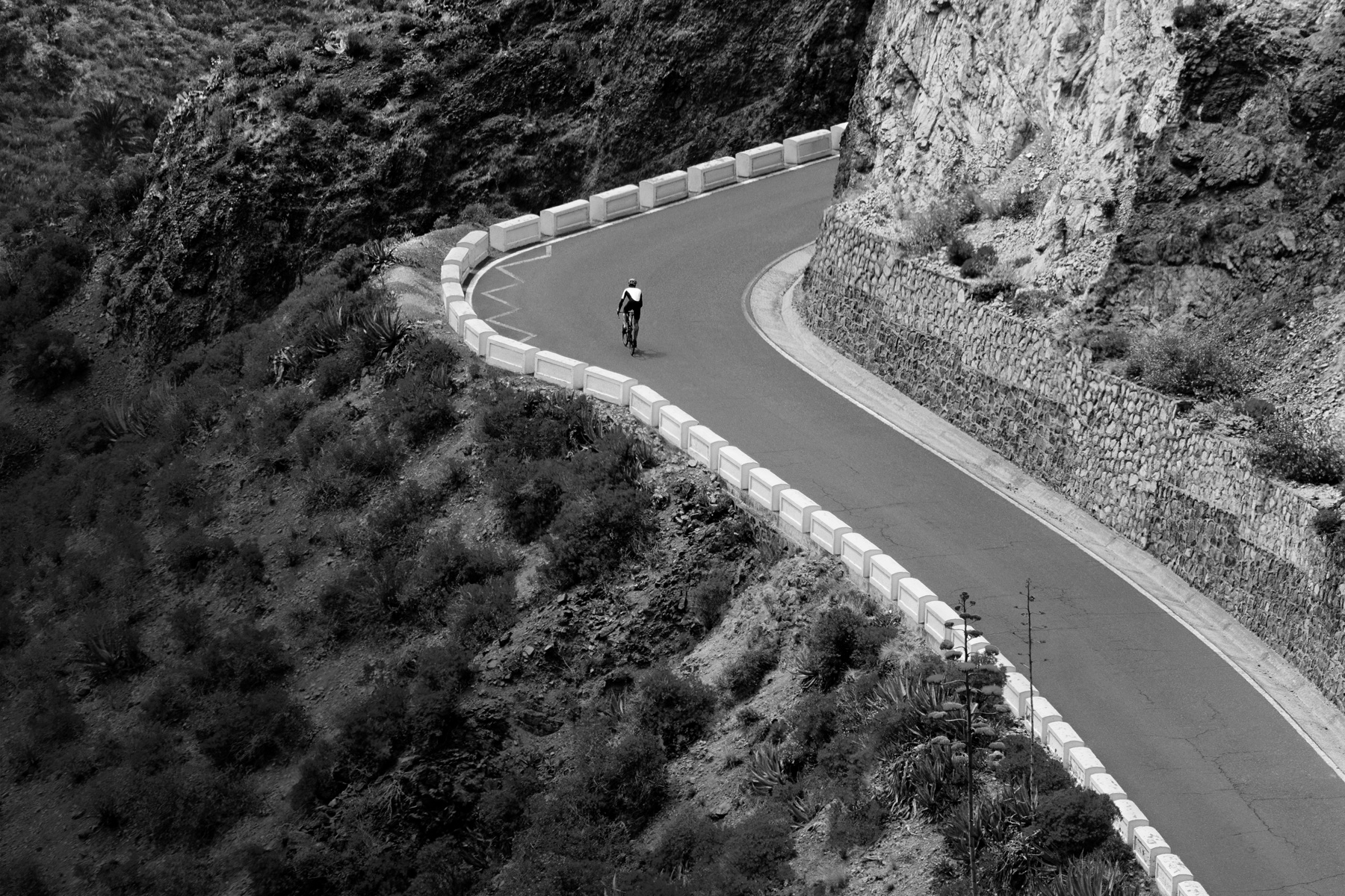 Un cycliste grimpe une route de montagne